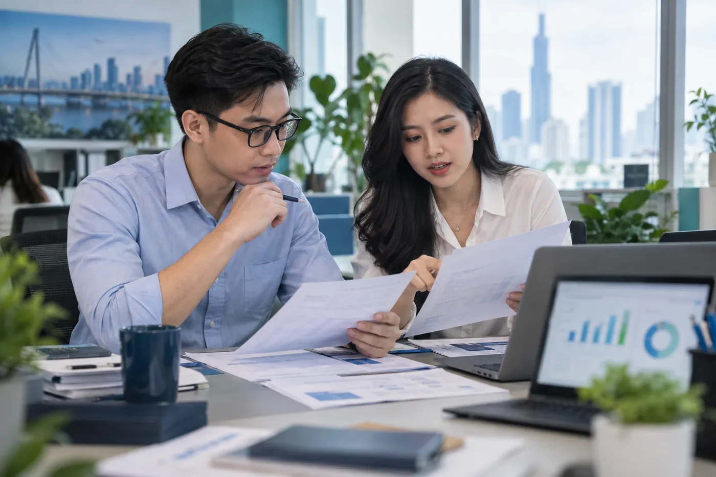 Hai chuyên viên đối chiếu chứng từ và số liệu quảng cáo